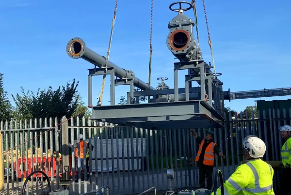 workers in hi vis with gas pipes on machinery